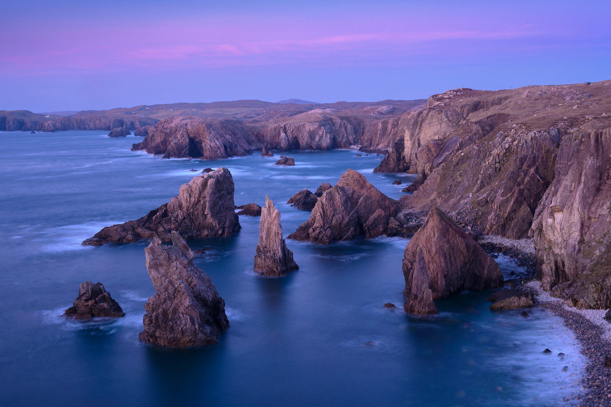 sea stacks and rock cliffs on the coast at dusk